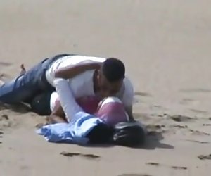 阿拉伯头巾的女孩与她的bf抓住了具有性别上的海滩